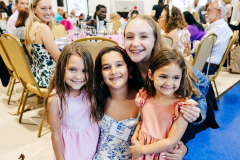 A group of happy children and adults at a community gathering, smiling and enjoying the event.