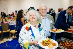 Happy seniors enjoying a community event with food and friends.