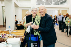 A joyful elderly couple at a community event, engaging in conversation and sharing a happy moment.